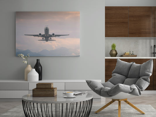 Leinwand mit Flugzeug beim Start über Bergen und Wolken