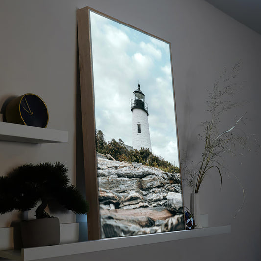 LED-Bild mit Leuchtturmmotiv im braunen Holzrahmen, weißer Leuchtturm auf Felsen