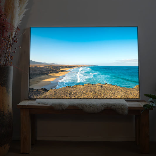 LED-Bild mit Rahmen: Strand, Meer und Küste mit sanften Wellen im Sonnenlicht.