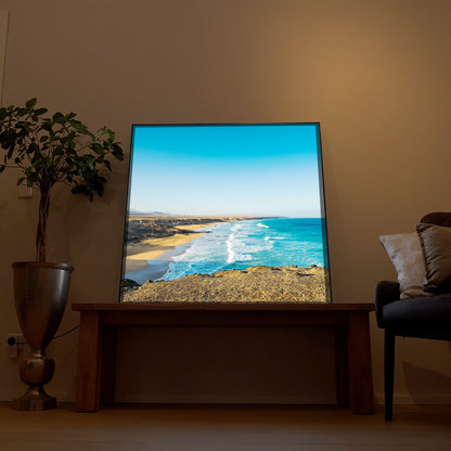 LED-Bild mit Rahmen: Sandstrand entlang der Küste, türkisfarbenes Meer und Himmel.