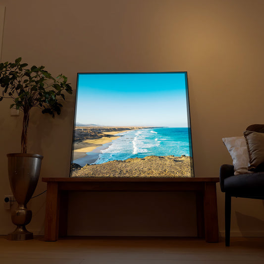 LED-Bild mit Rahmen: Sandstrand entlang der Küste, türkisfarbenes Meer und Himmel.