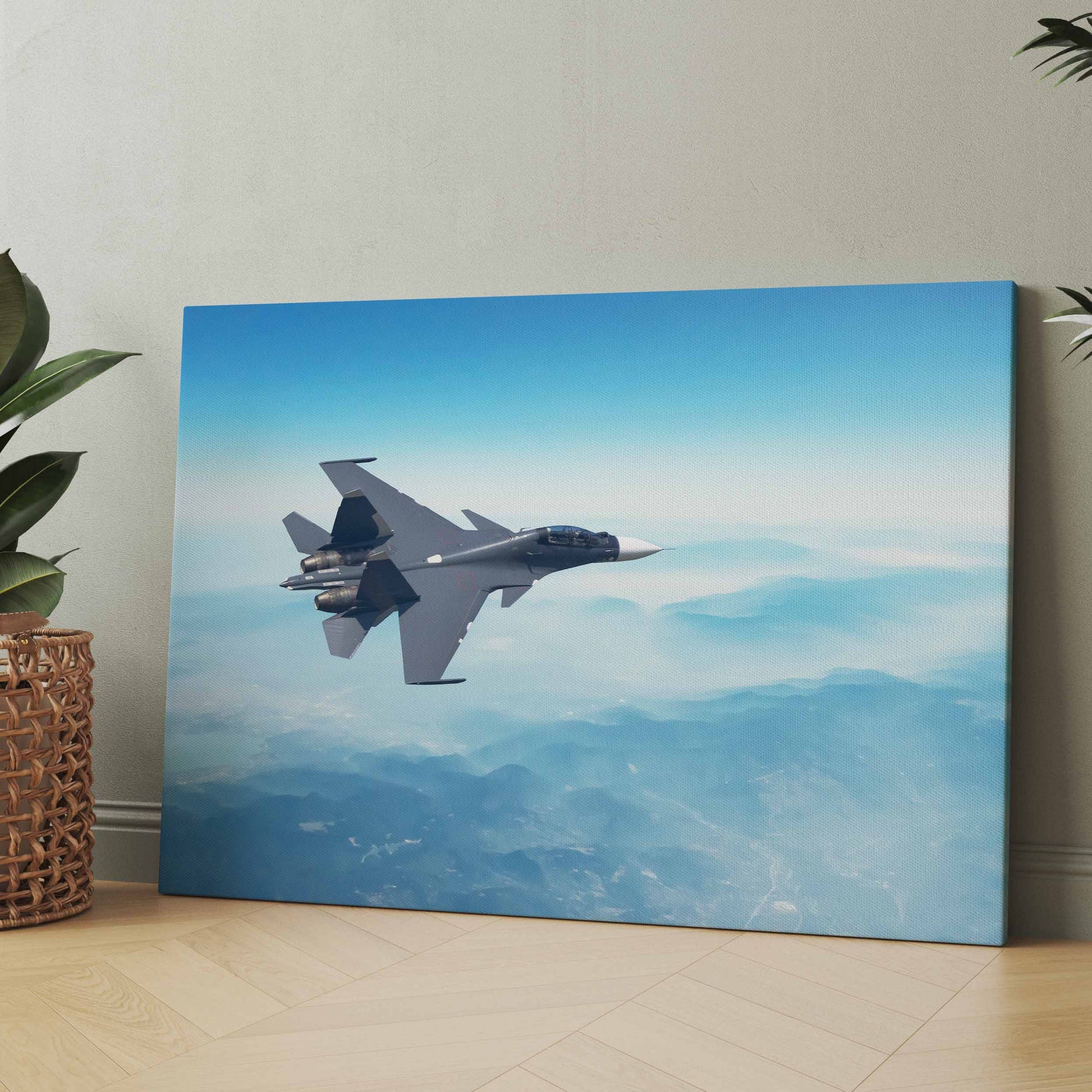 Leinwand mit Kampfjet im Flug, graues Flugzeug vor blauem Himmel und Bergen