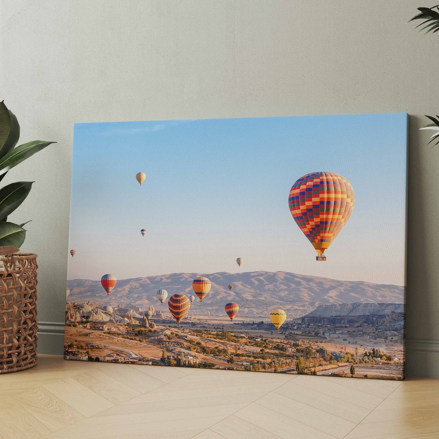 Leinwandbild mit Heißluftballons über einer felsigen Landschaft im Tal