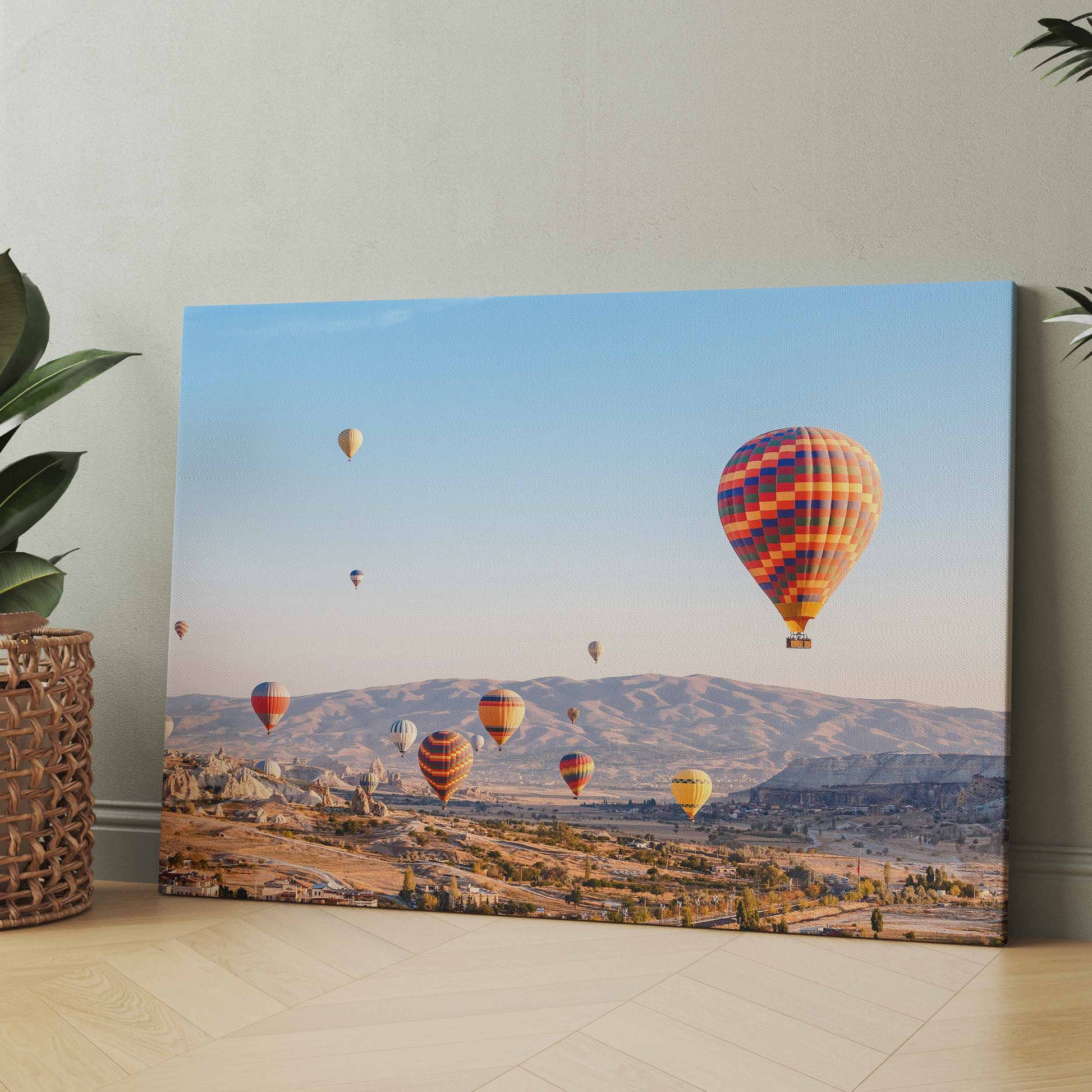 Leinwandbild mit Heißluftballons über einer felsigen Landschaft im Tal